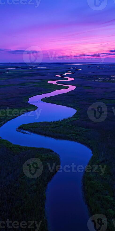 A river flowing through a marsh at sunset photo