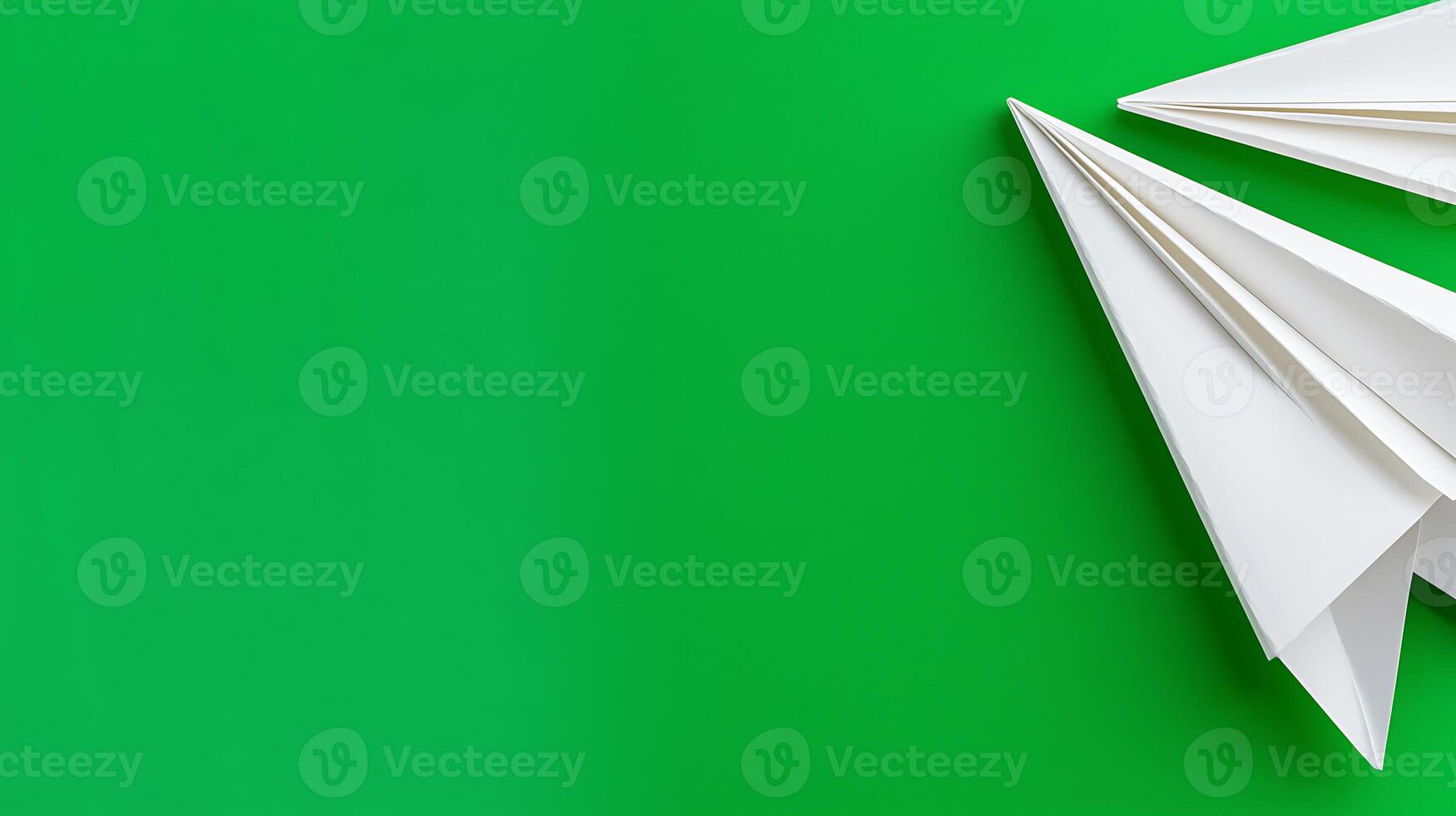 White paper airplanes on a vibrant green background, symbolizing creativity and playfulness photo