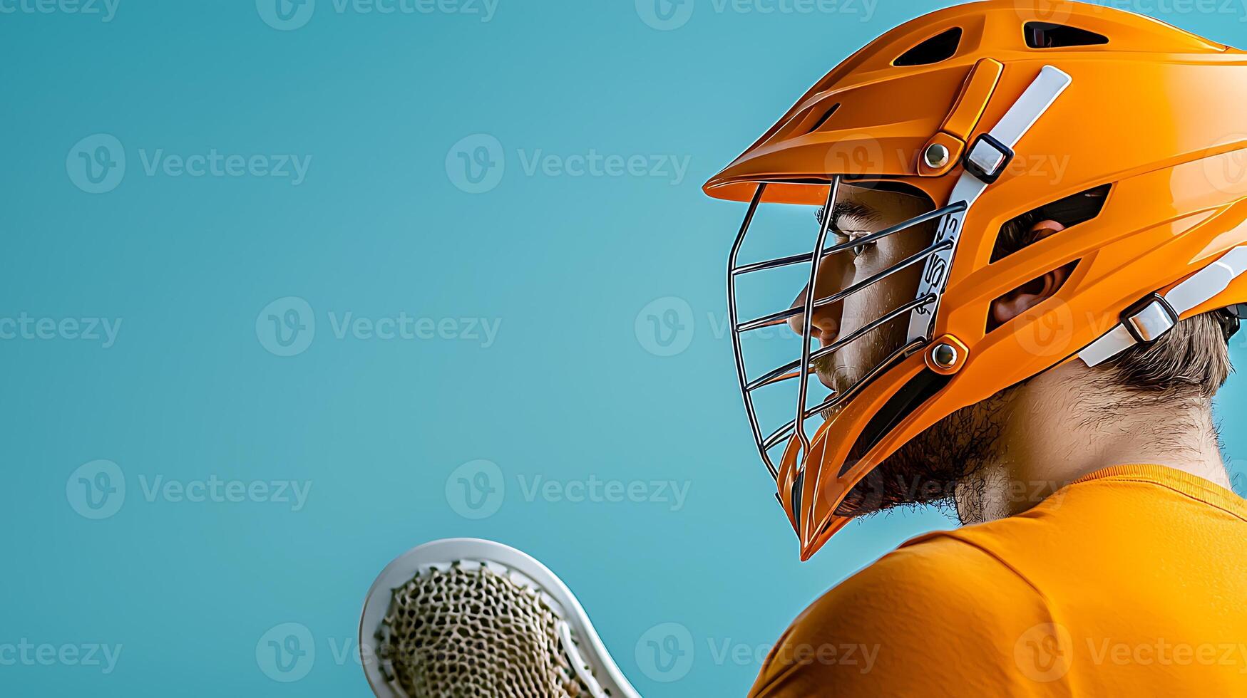 Young athlete in an orange lacrosse helmet poses against a blue background, showcasing sports gear photo