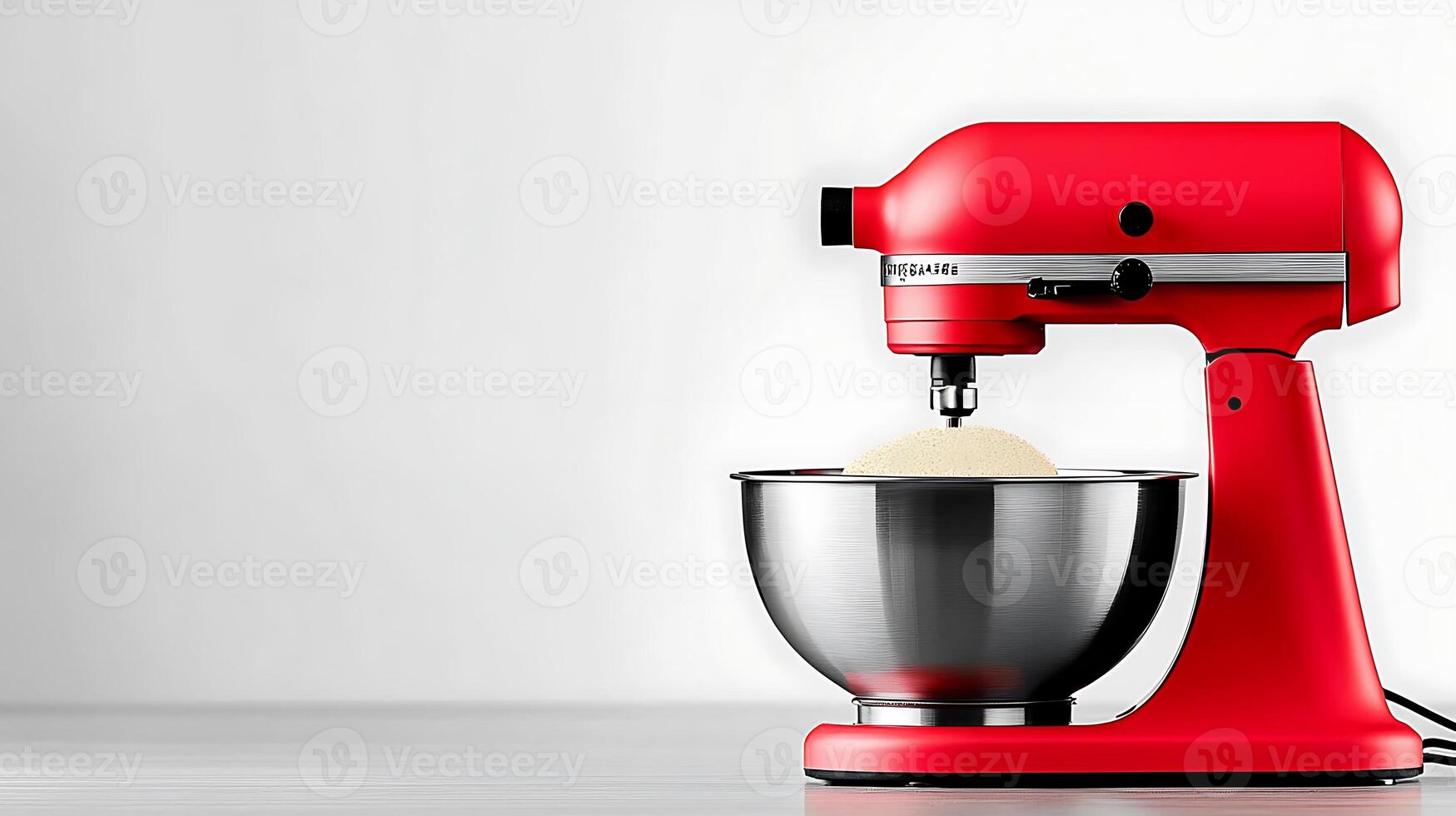 Vibrant red kitchen mixer with stainless steel bowl, preparing dough against a minimalist backdrop photo