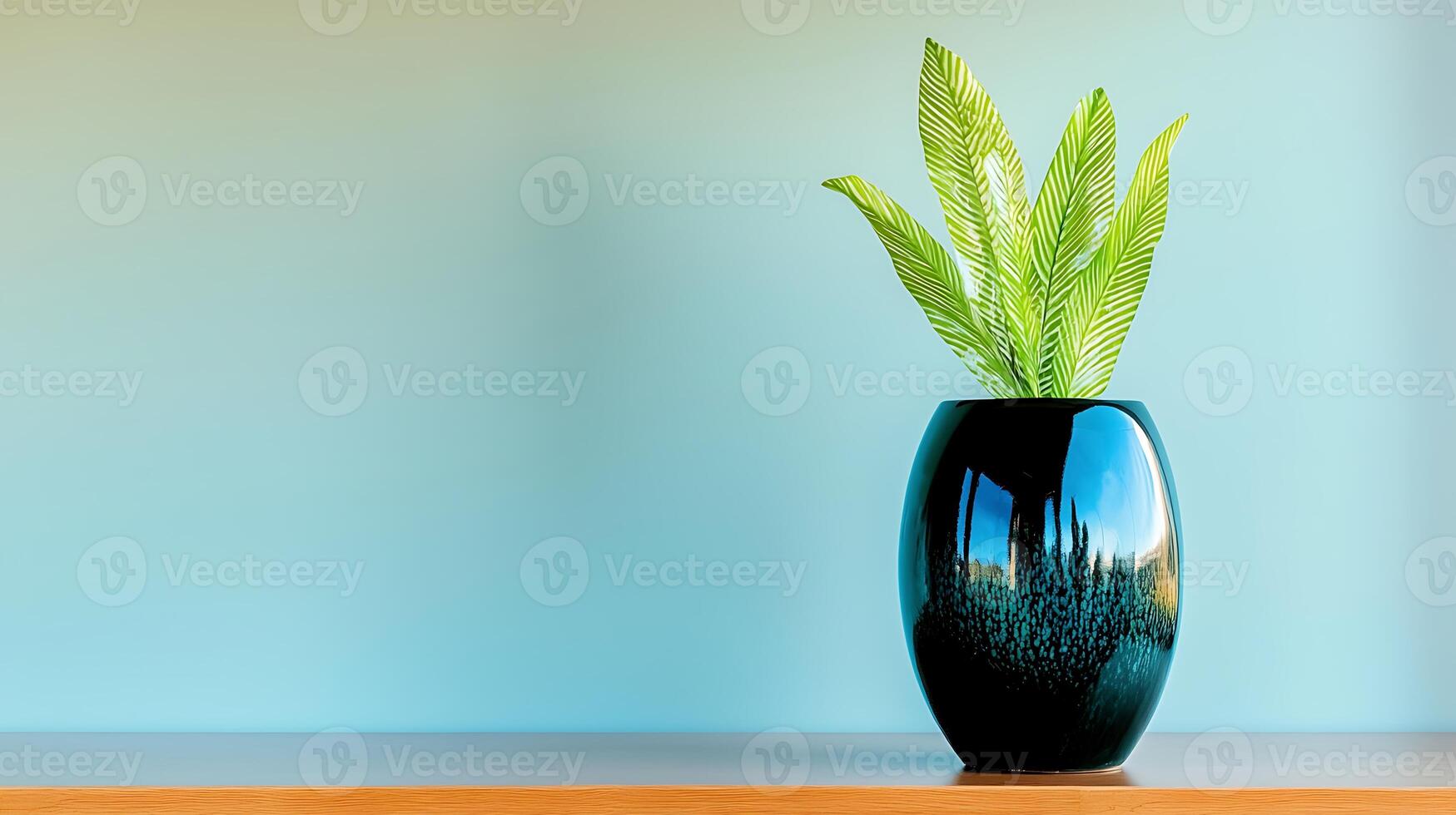 A vibrant green plant in a glossy blue vase on a wooden shelf against a soft gradient background photo
