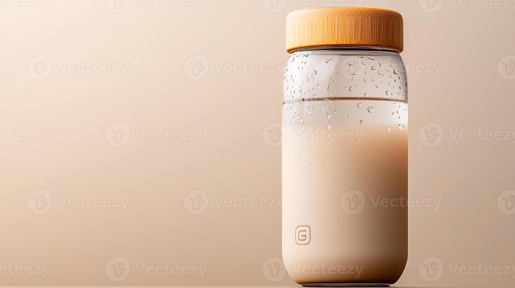 A stylish transparent bottle filled with a creamy beverage, set against a soft beige background photo