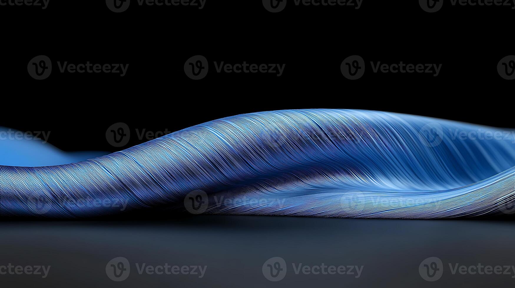 Close-up of a flowing blue fabric draped elegantly against a dark background, showcasing texture photo