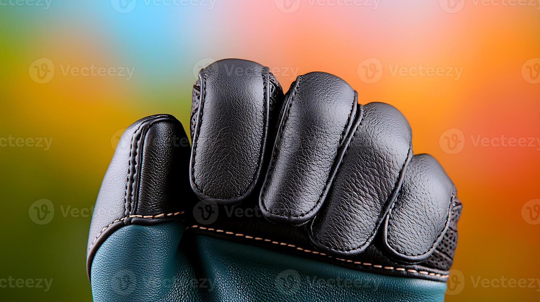 Close-up of a black leather glove in a colorful blurred background, showcasing its texture and design photo