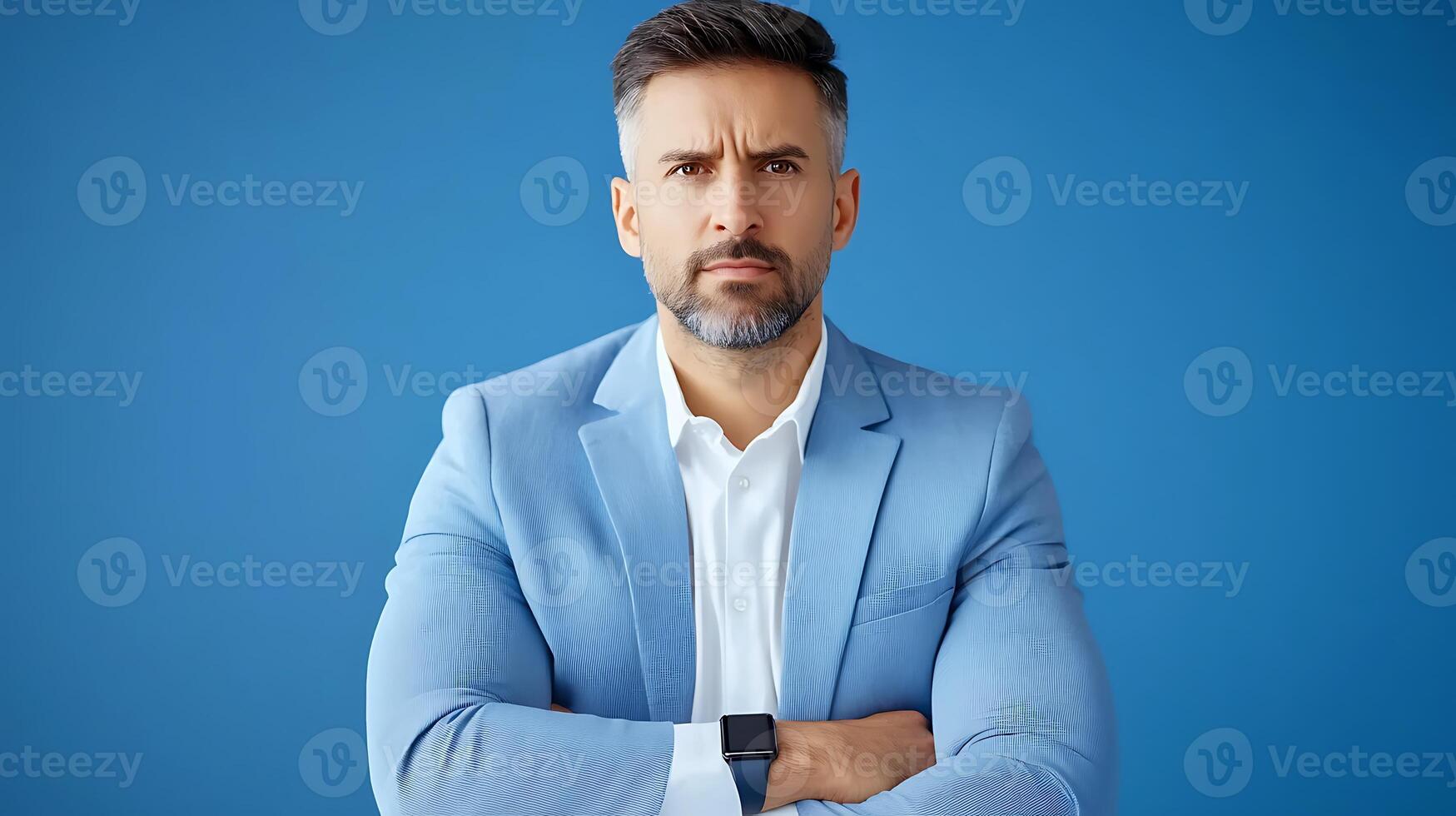 Confident businessman in a light blue suit standing with arms crossed against a blue background photo