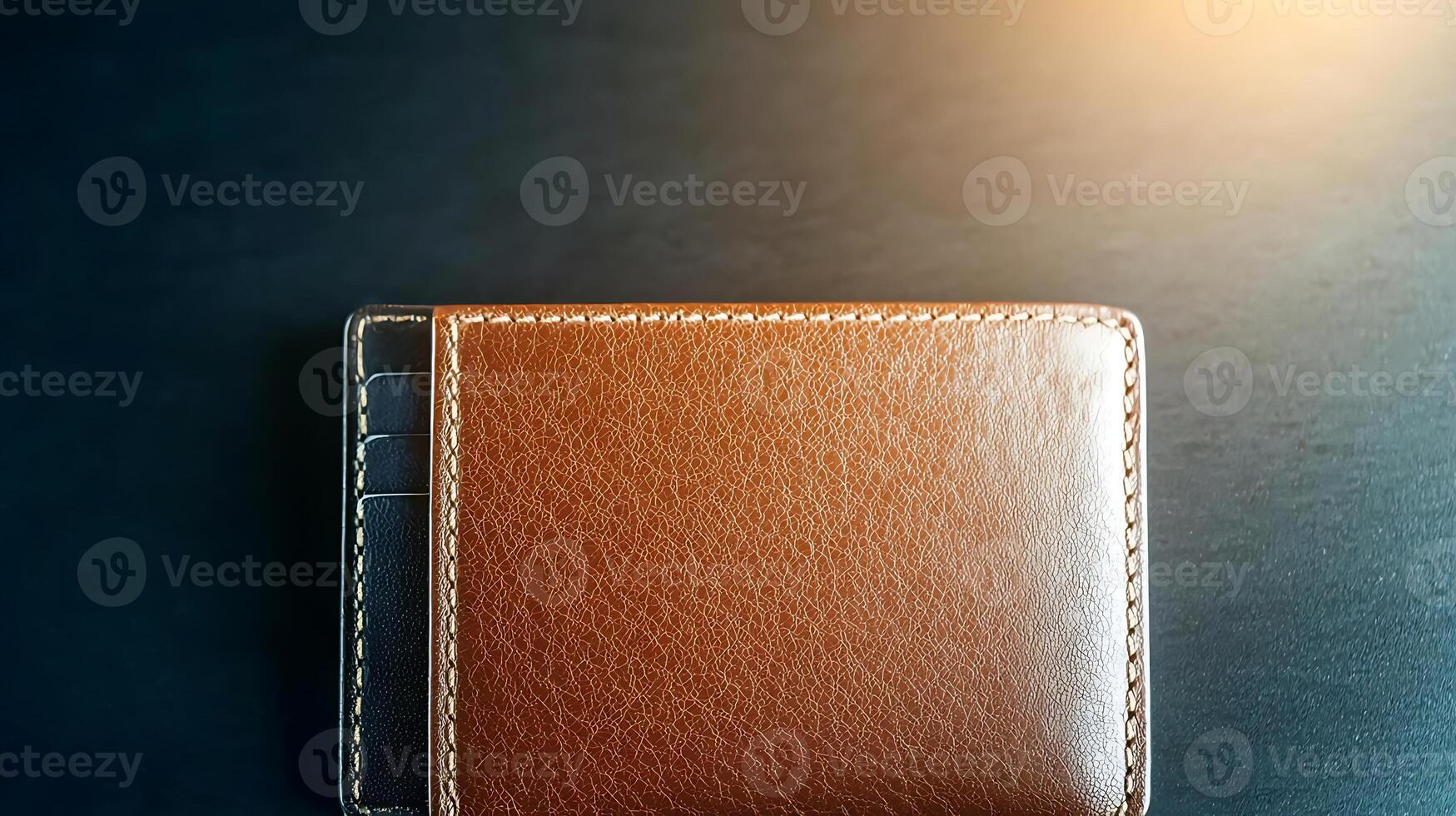 A close-up view of a brown leather wallet resting on a dark wooden surface with soft lighting photo
