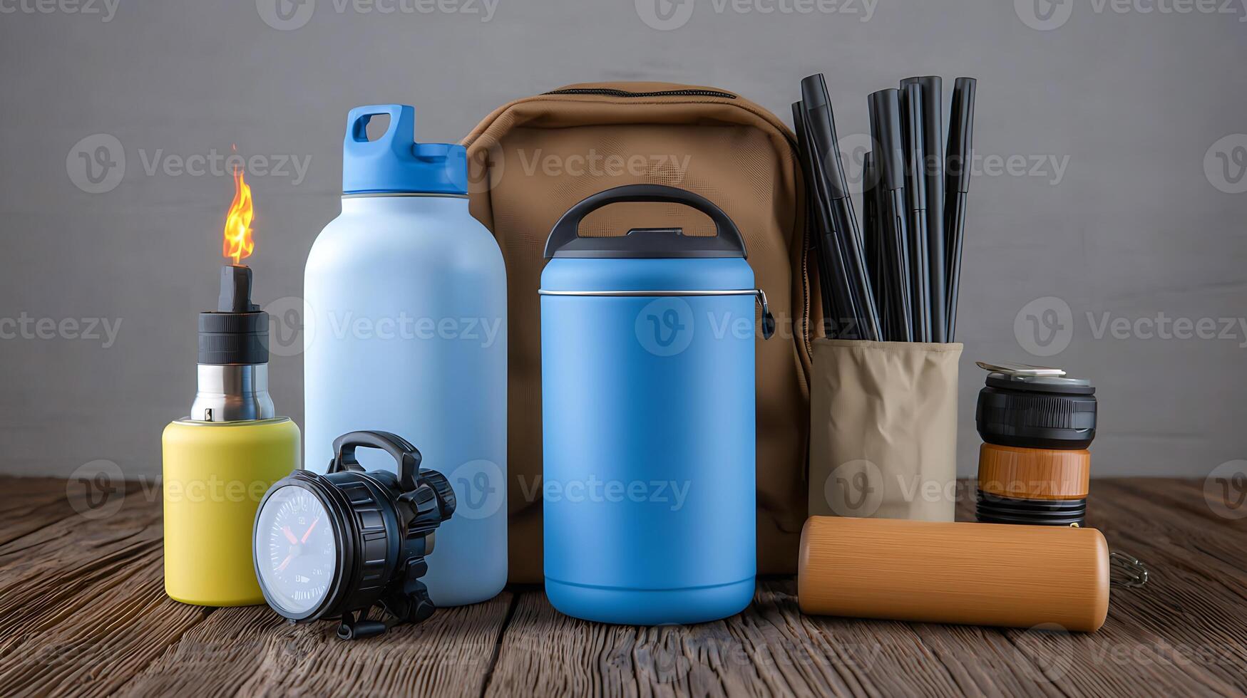 A collection of outdoor gear including bottles, a backpack, and a lantern on a wooden surface photo