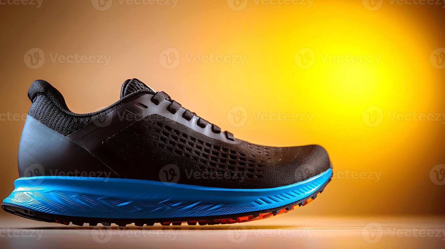 Sleek black running shoe with blue accents displayed against a warm gradient background photo