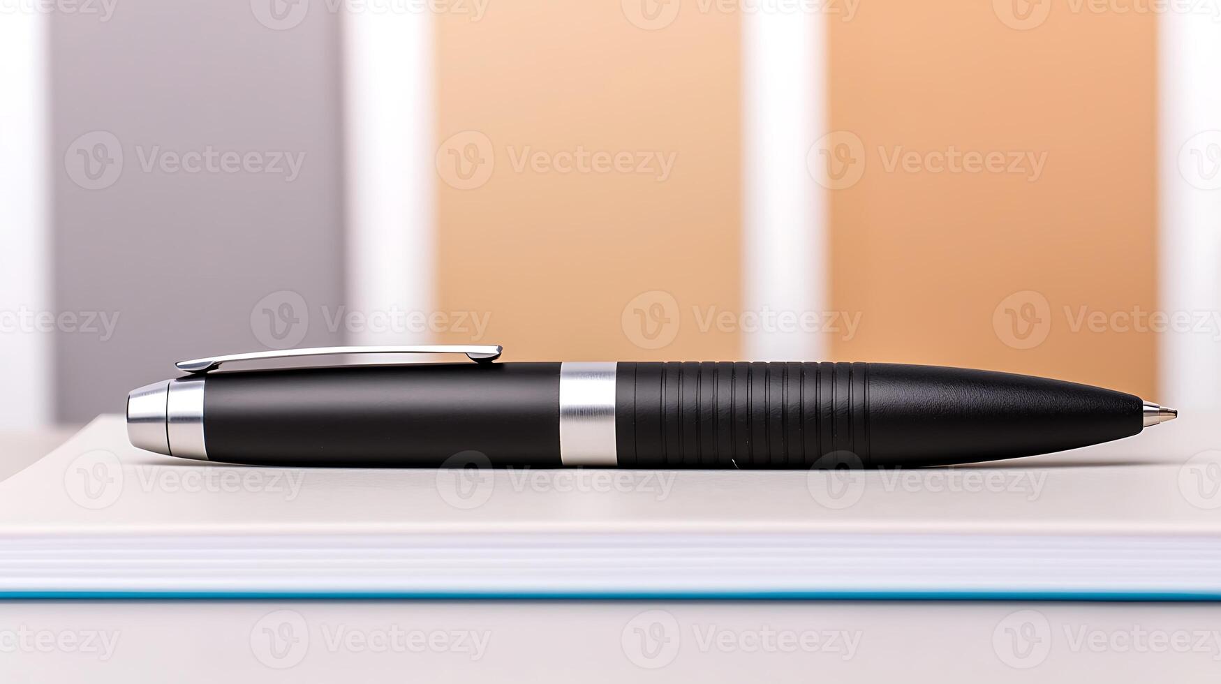 Sleek black pen resting on a notebook with a blurred background of soft pastel colors photo