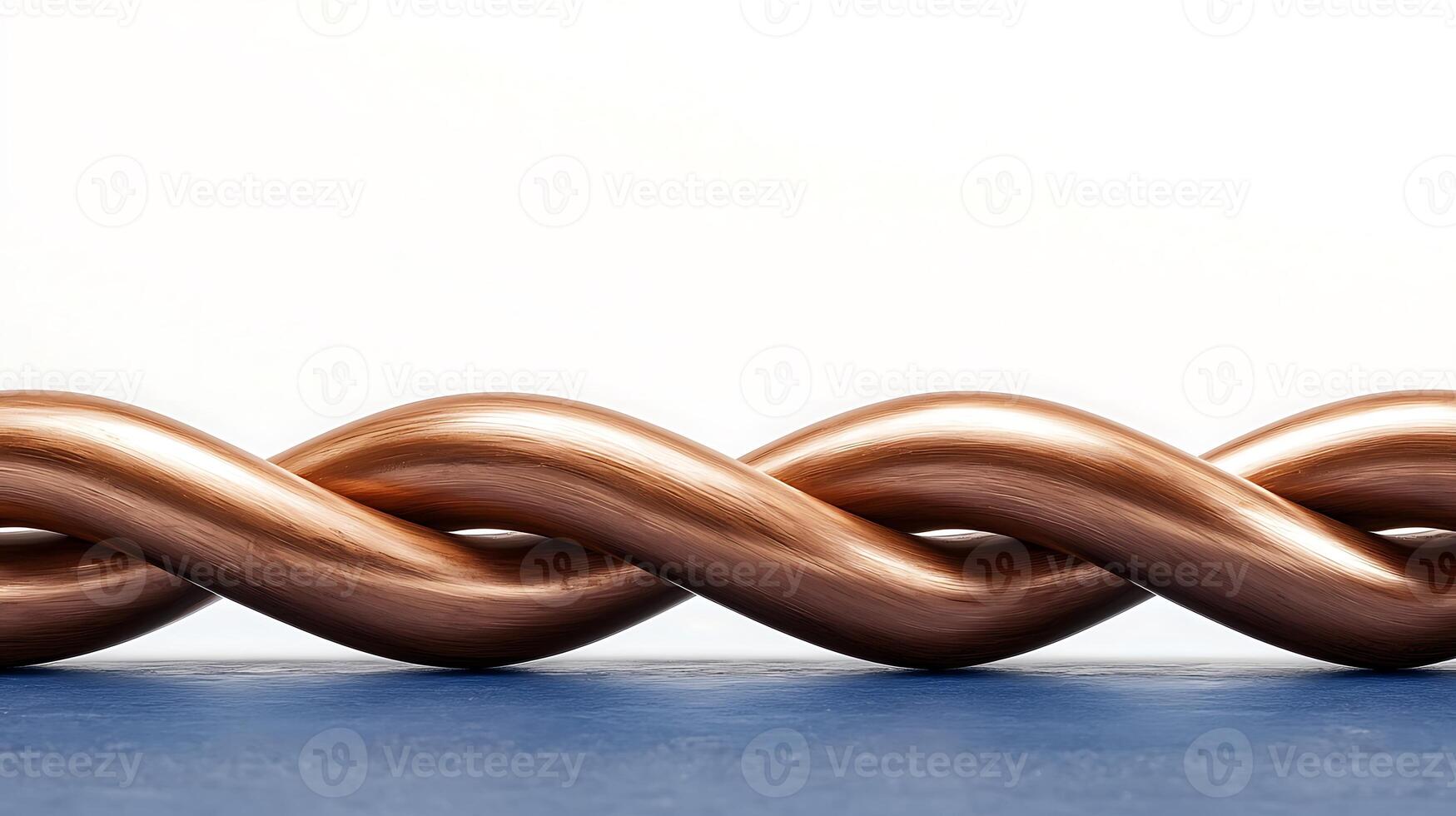 Twisted copper wire on a blue surface with a plain background highlighting its texture photo