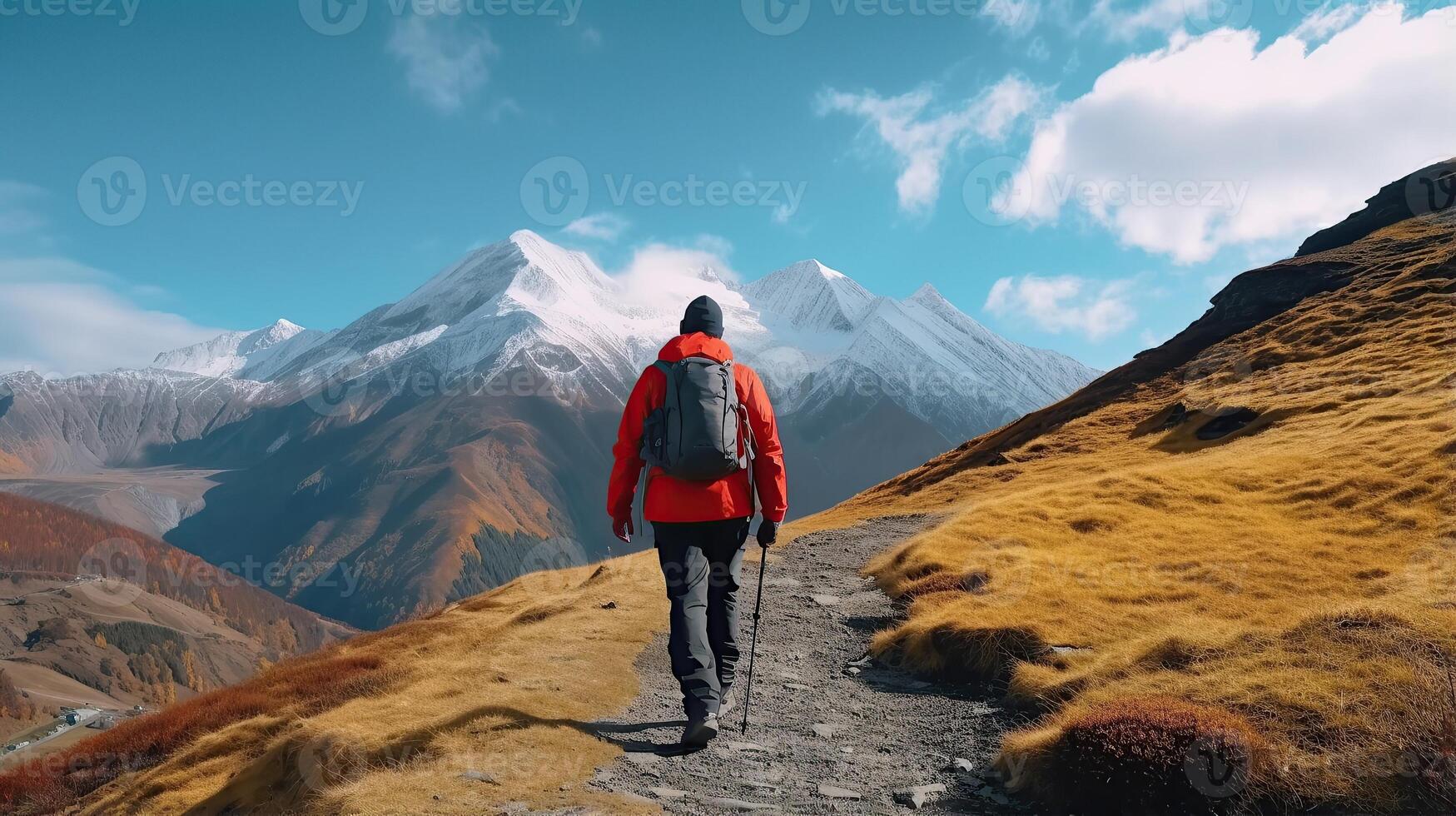 A person walking on a trail in the mountains photo