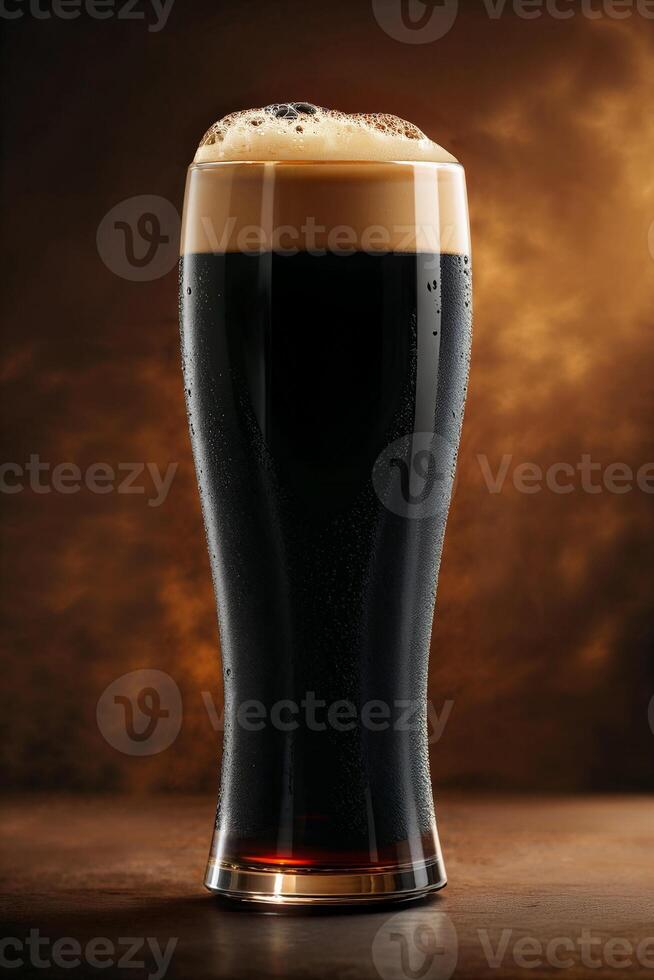 Cold glass of dark beer with foam on brown background photo