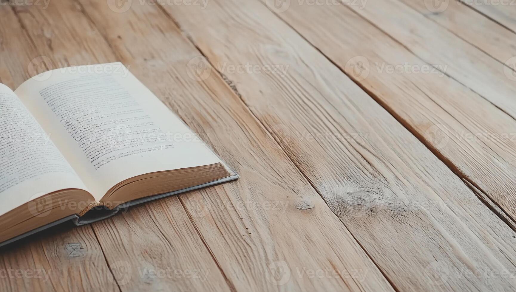 An open book lies on a wooden table, inviting reading and reflection. photo
