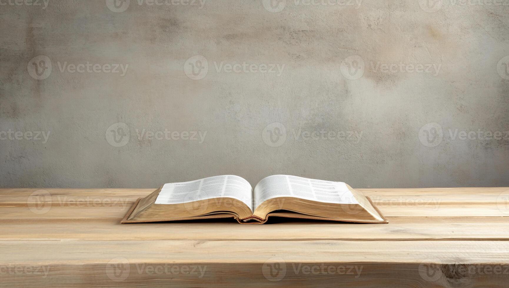 An open book resting on a wooden table against a neutral background. photo