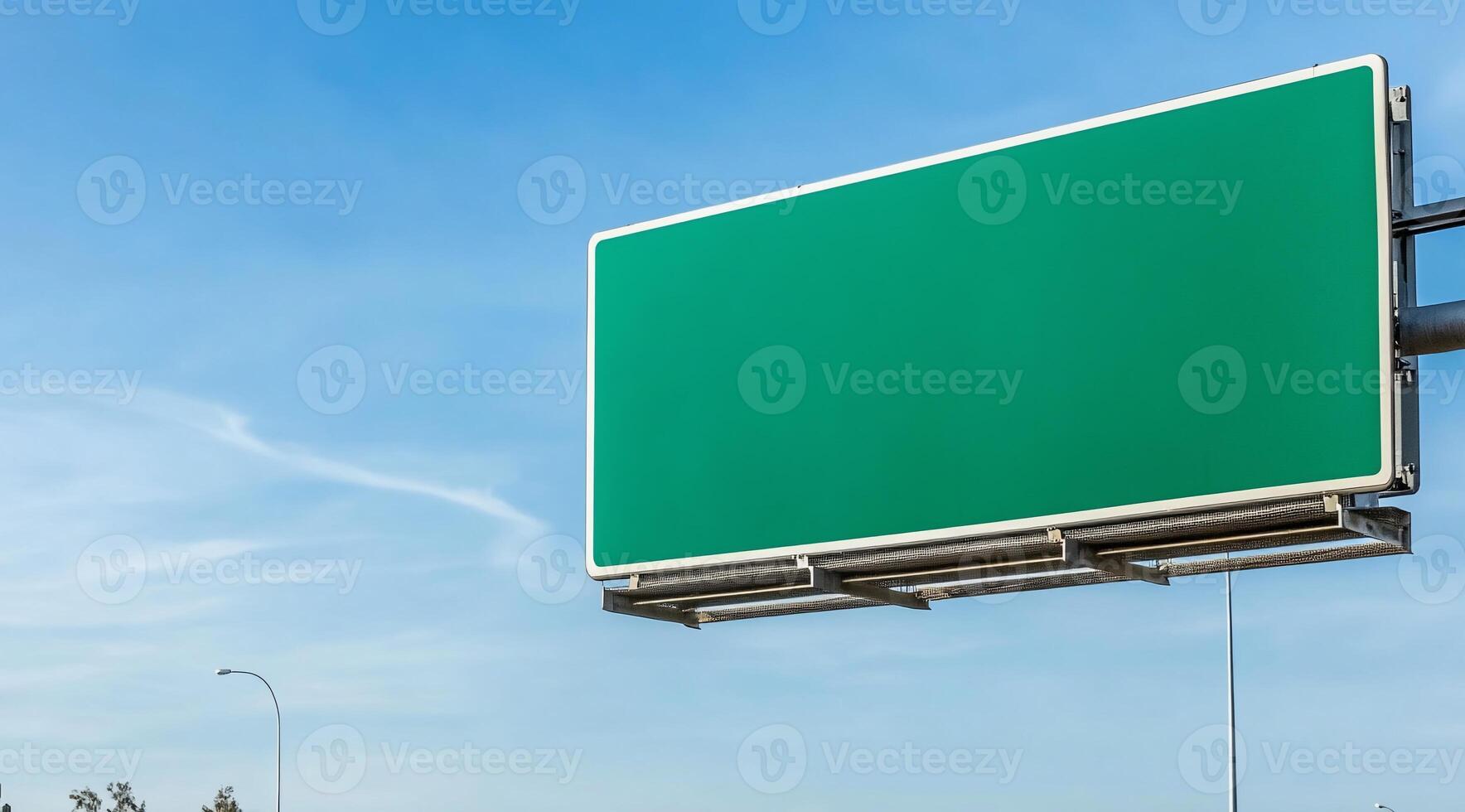 A blank green highway billboard against a blue sky. photo