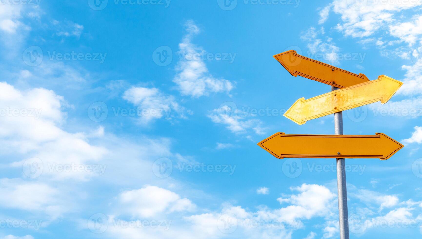 A directional signpost with multiple arrows against a blue sky. photo