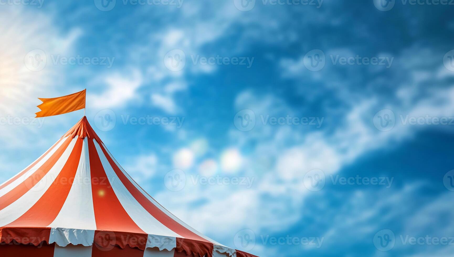 A colorful circus tent under a bright sky with a waving flag. photo