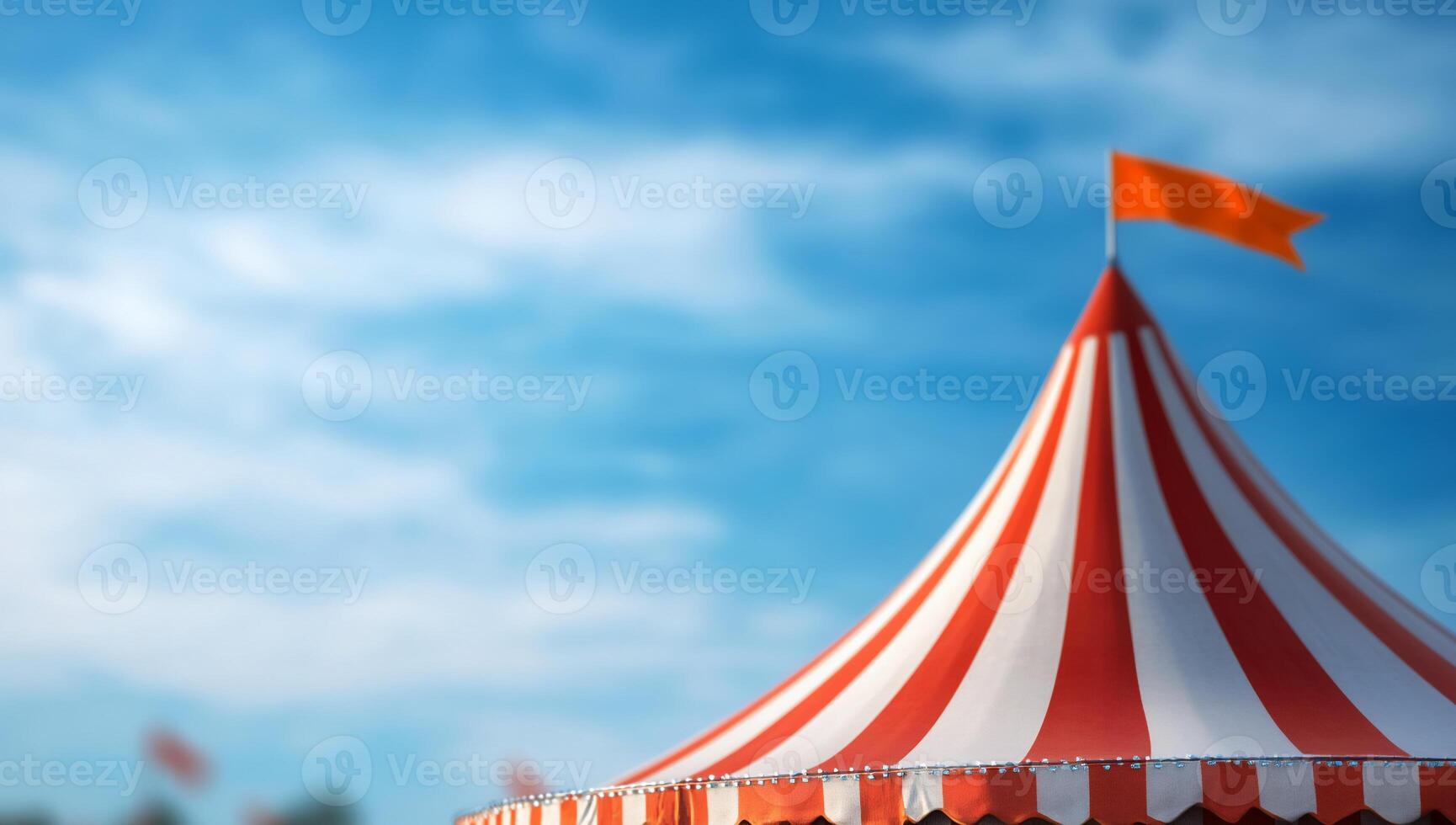 A colorful circus tent under a blue sky with a flag on top. photo
