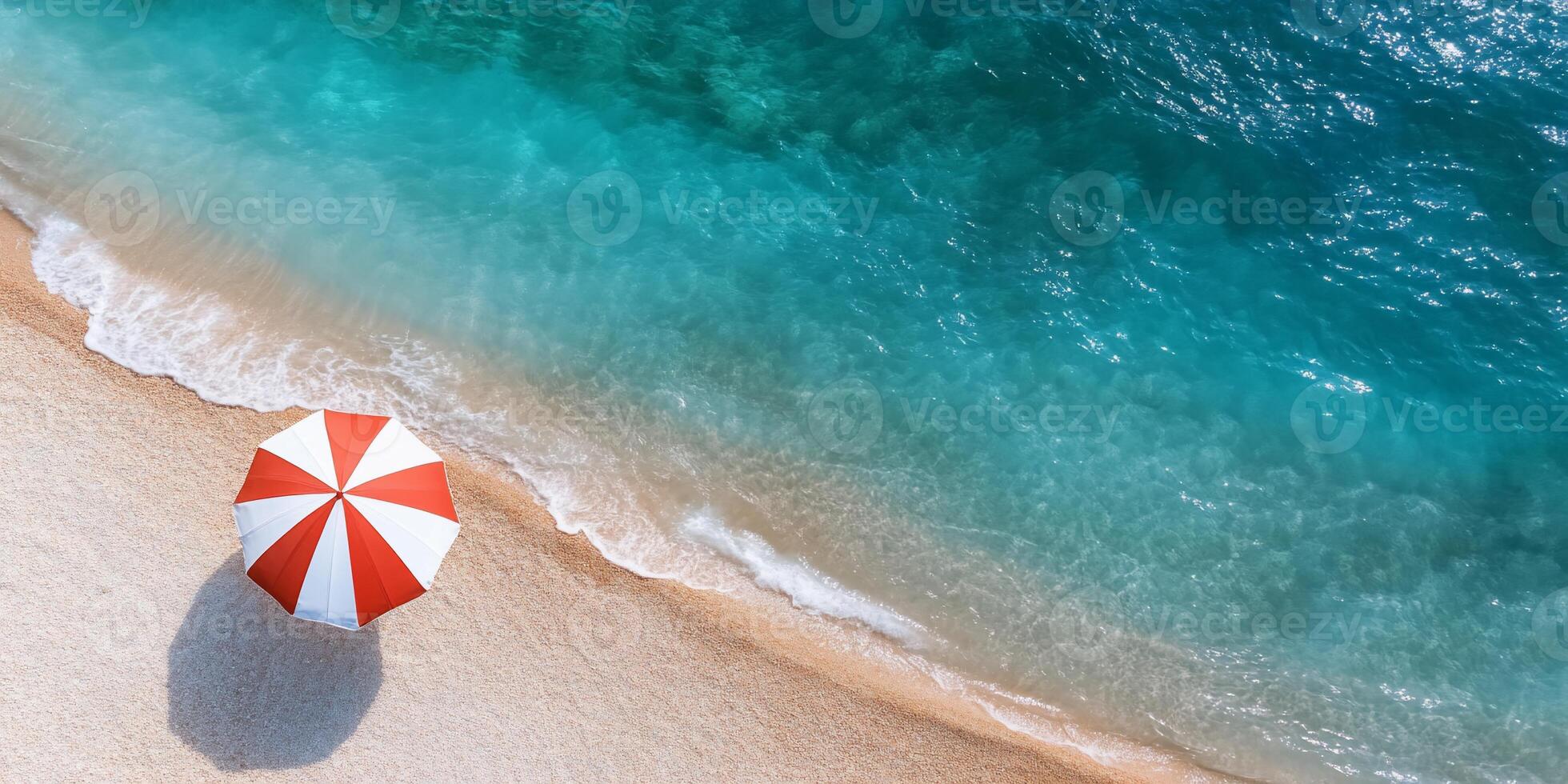 A vibrant beach scene featuring a red and white umbrella by the water. photo
