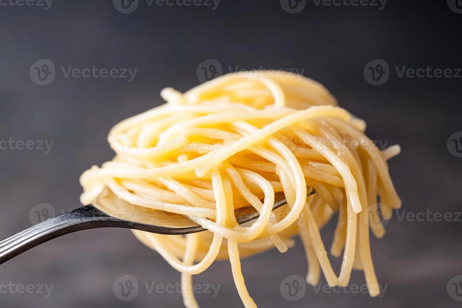 A fork holding a serving of cooked spaghetti noodles. photo