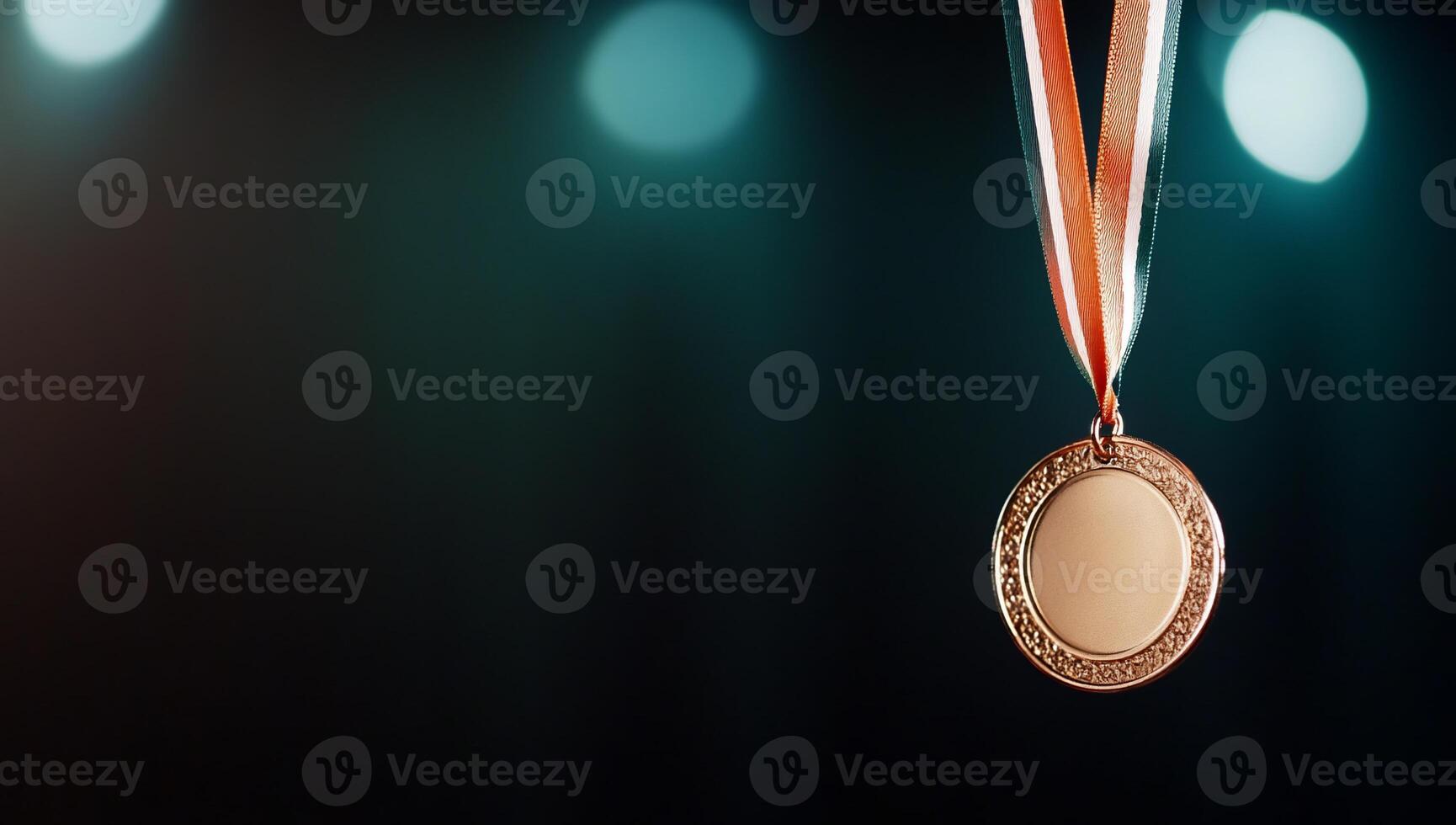 A bronze medal hanging from a ribbon against a blurred background. photo