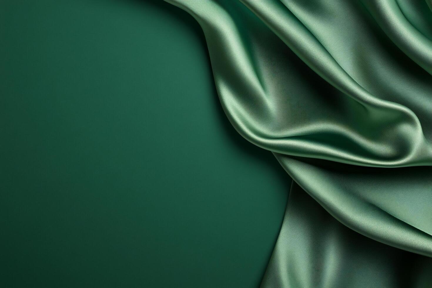 A smooth, flowing green fabric drapes elegantly against a dark backdrop. photo