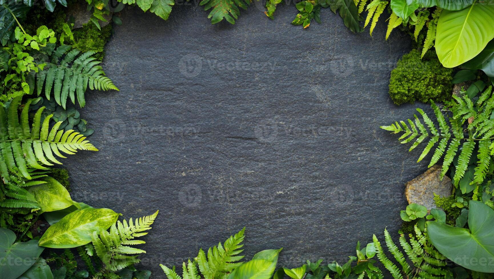 A textured slate surrounded by lush green foliage. photo
