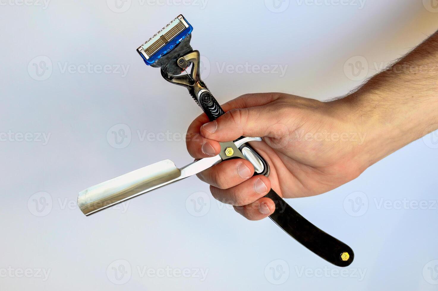 Male hand holding black straight razor and classic razor isolated on white background. Methods and tools of shaving photo