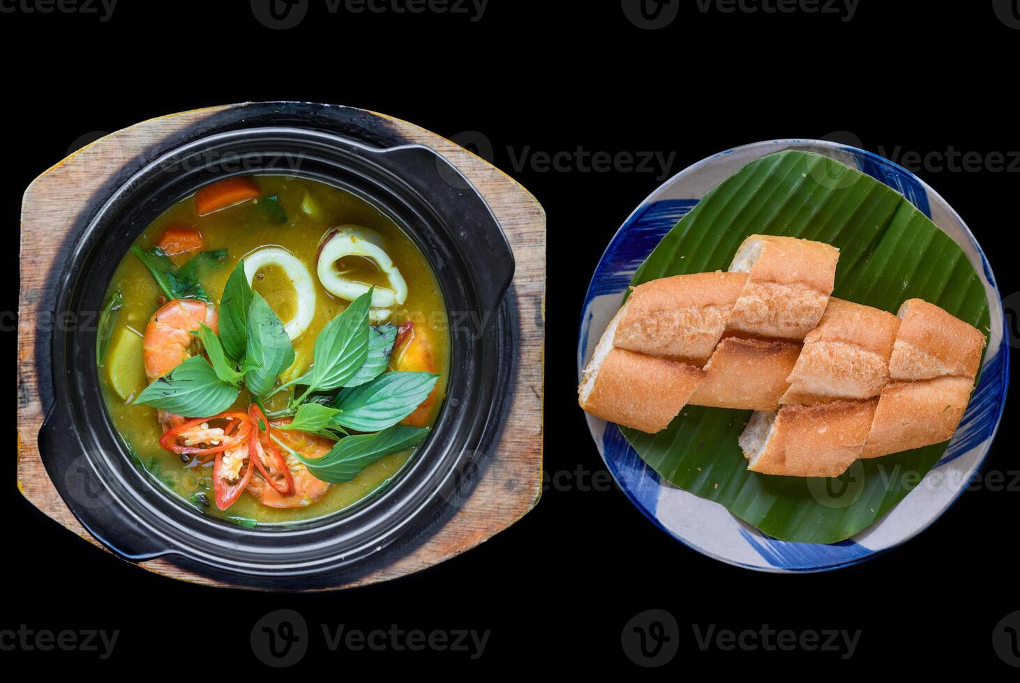 Vietnamese curry with shrimps and potato on black background for a menu with banh mi photo