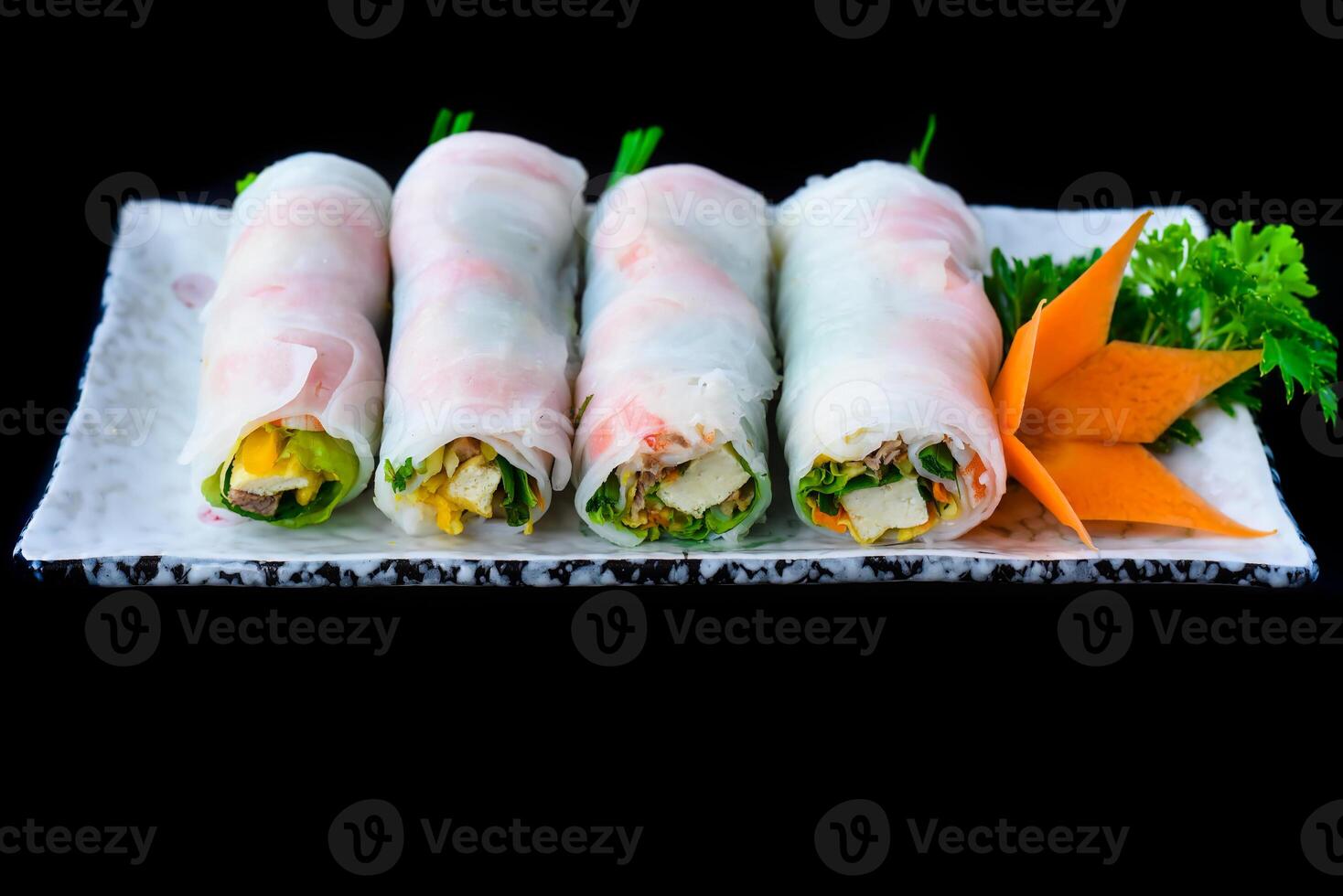 Vietnamese Pho spring rolls with seafood, tofu, vegetables isolated on black background for a menu photo