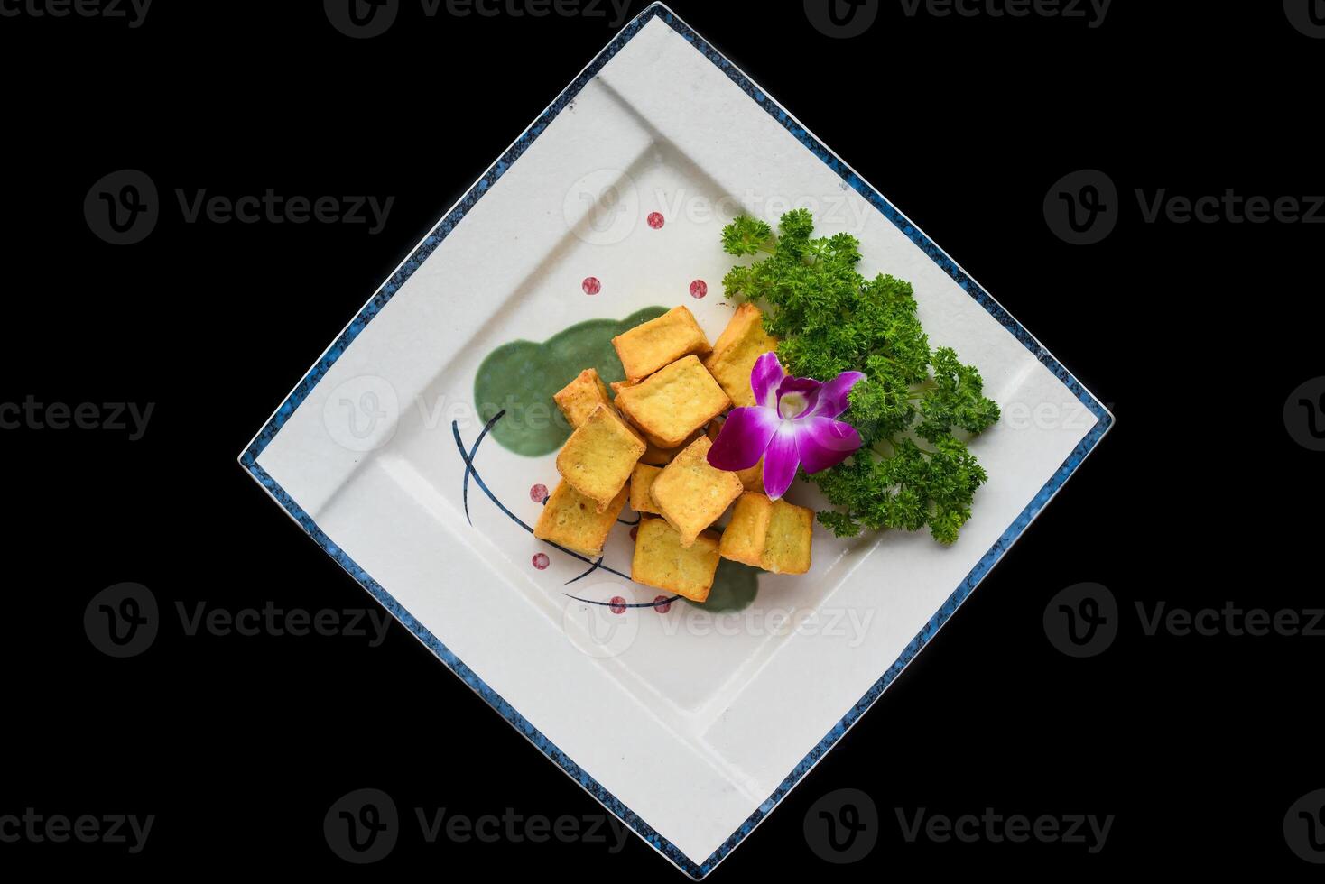 Vietnamese fried tofu on white plate isolated on black background for a menu top view photo