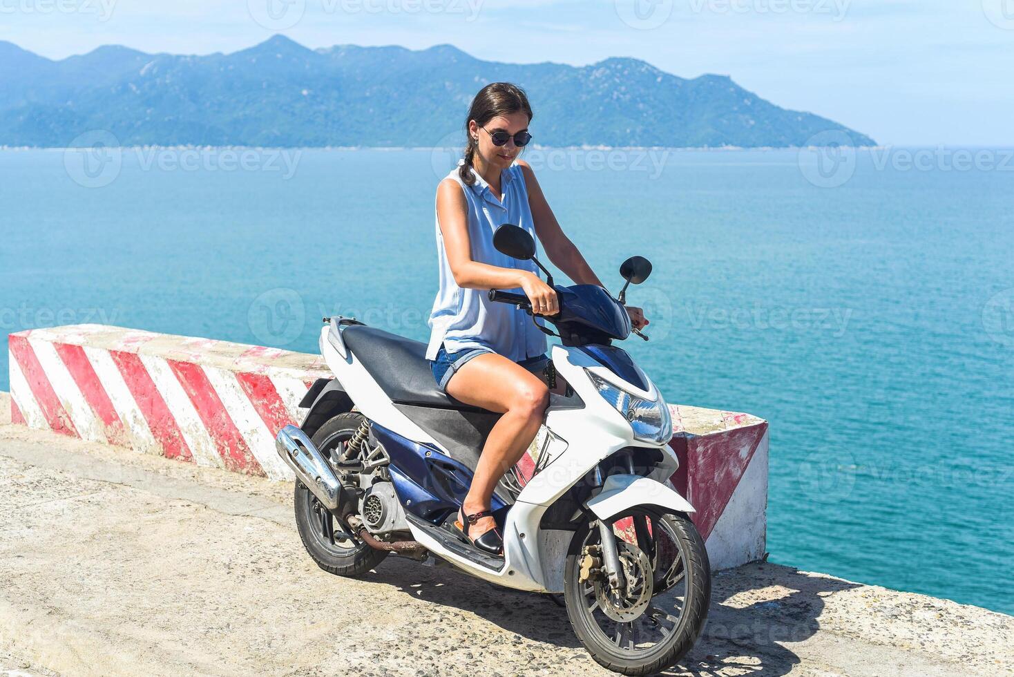 Young woman motorbike driver sitting against the south south china sea in vietnam photo