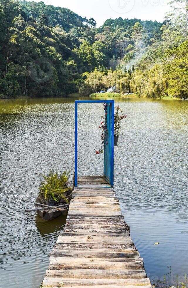 Pier with opened door toward lake and pine forest like metaphor photo