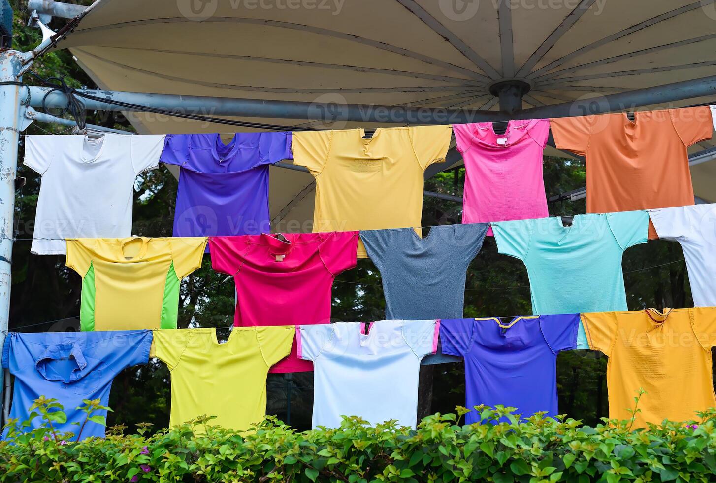 Many colorful different t shirts hanging on ropes photo