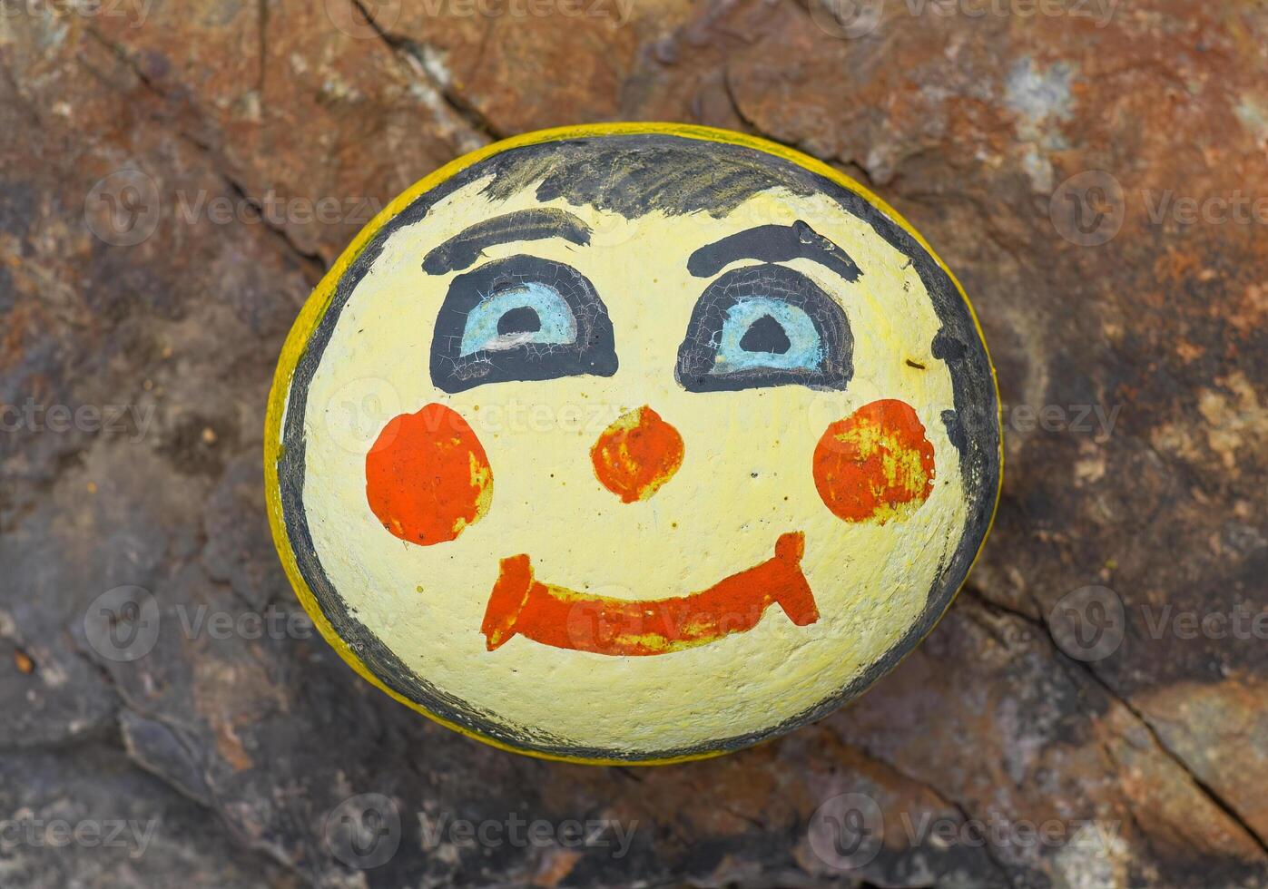 Painted sea stone with scary face Decoration for a garden. photo