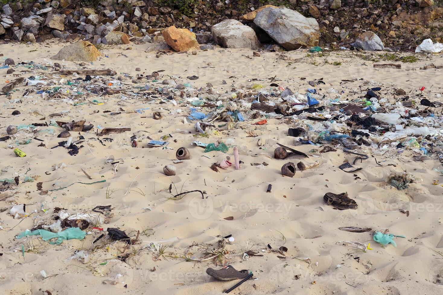 Terrible view of dirty beach in Khanh Hoa province with much trash on stones photo
