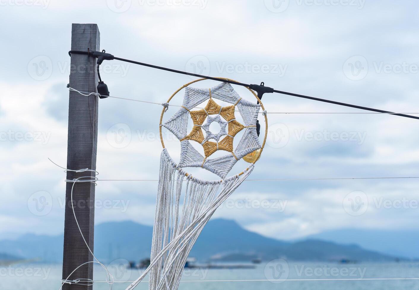 Example of usual star pattern knots of macrame technique made of white and golden threads photo