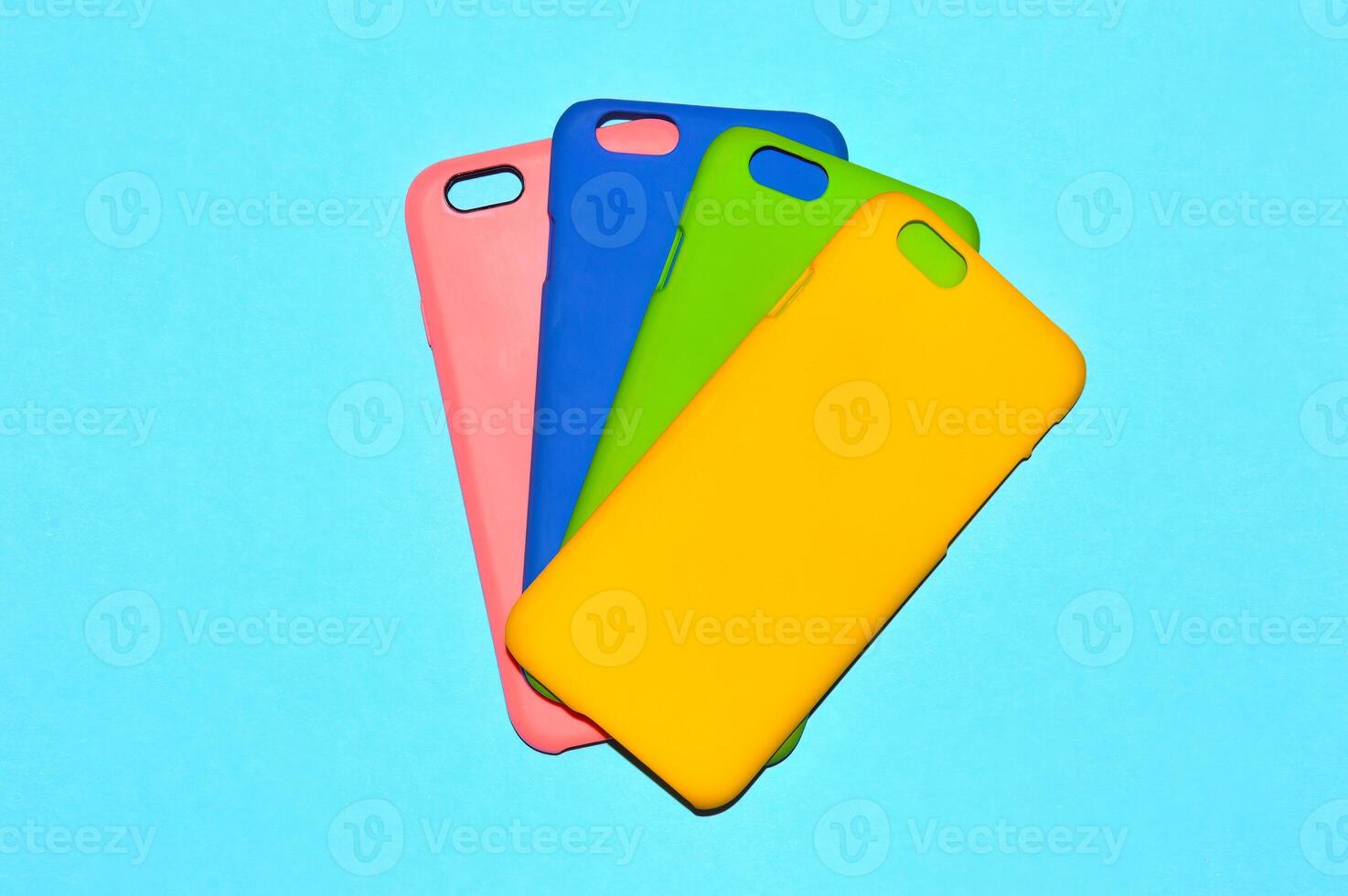 Colorful phone cases isolated on blue background photo