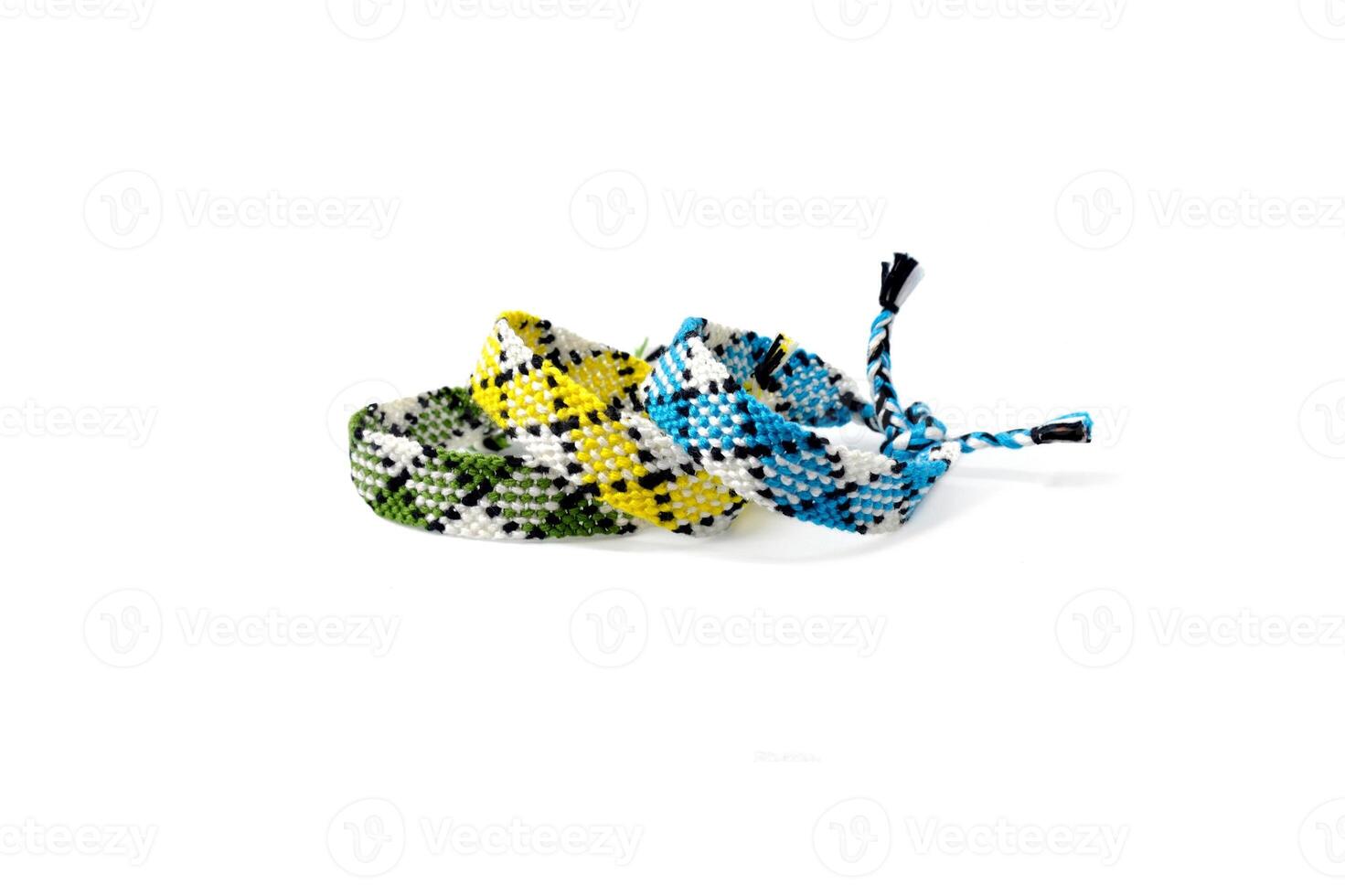3 multicolored woven DIY friendship bracelets made of embroidery bright thread with knots isolated on white background photo