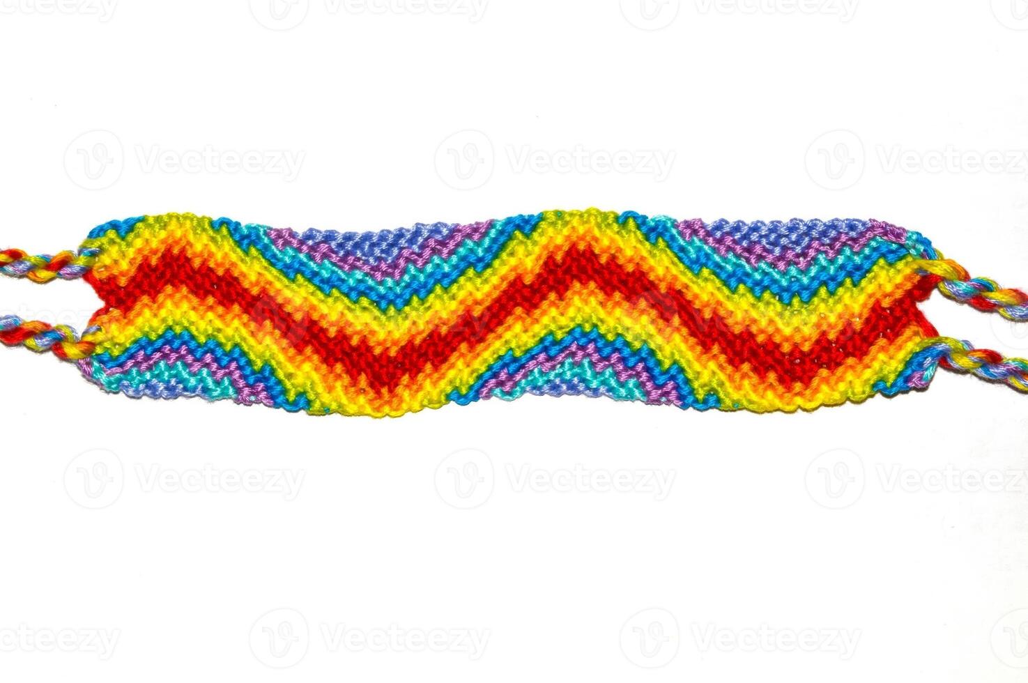 Multicolored woven DIY friendship bracelet handmade of embroidery bright thread with knots isolated on white background top view photo
