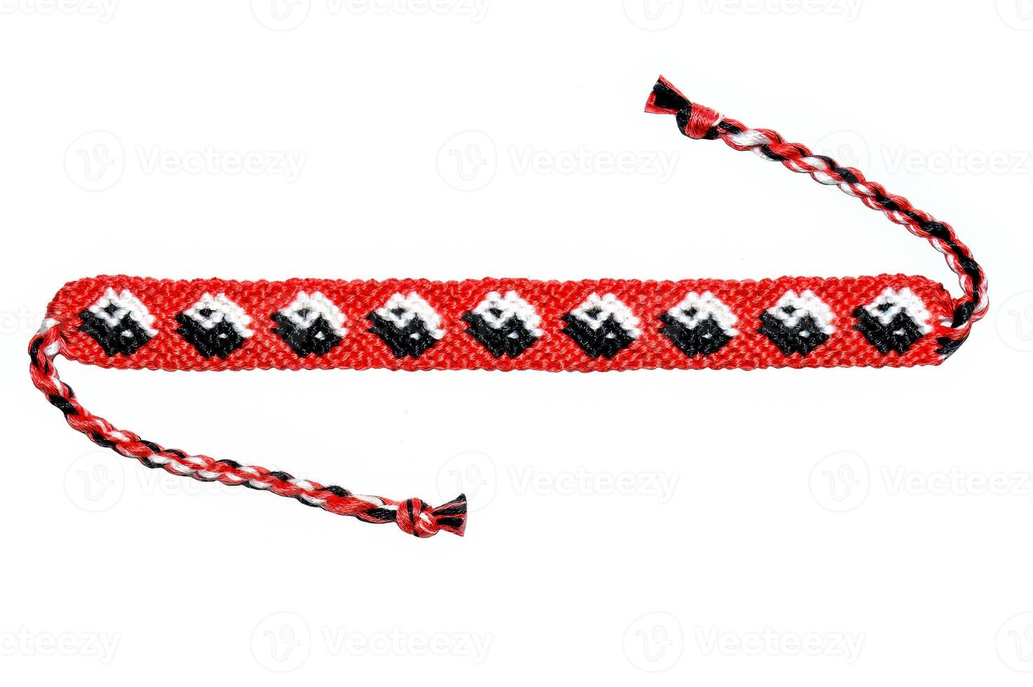 Red woven DIY friendship bracelet with pattern Yin and yang handmade of embroidery bright thread with knots isolated on white background photo