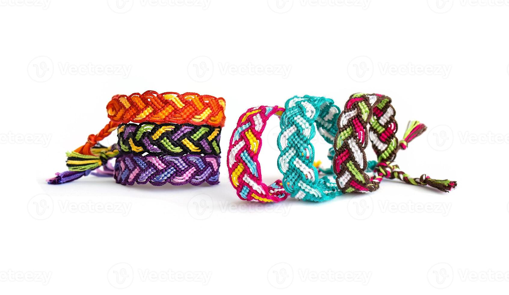 Five multicolored woven DIY friendship bracelets handmade of embroidery bright thread with knots isolated on white background photo