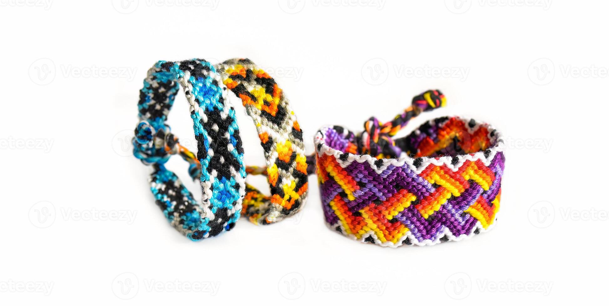 3 Multicolored DIY friendship bracelets made of embroidery bright thread with knots isolated on white background photo