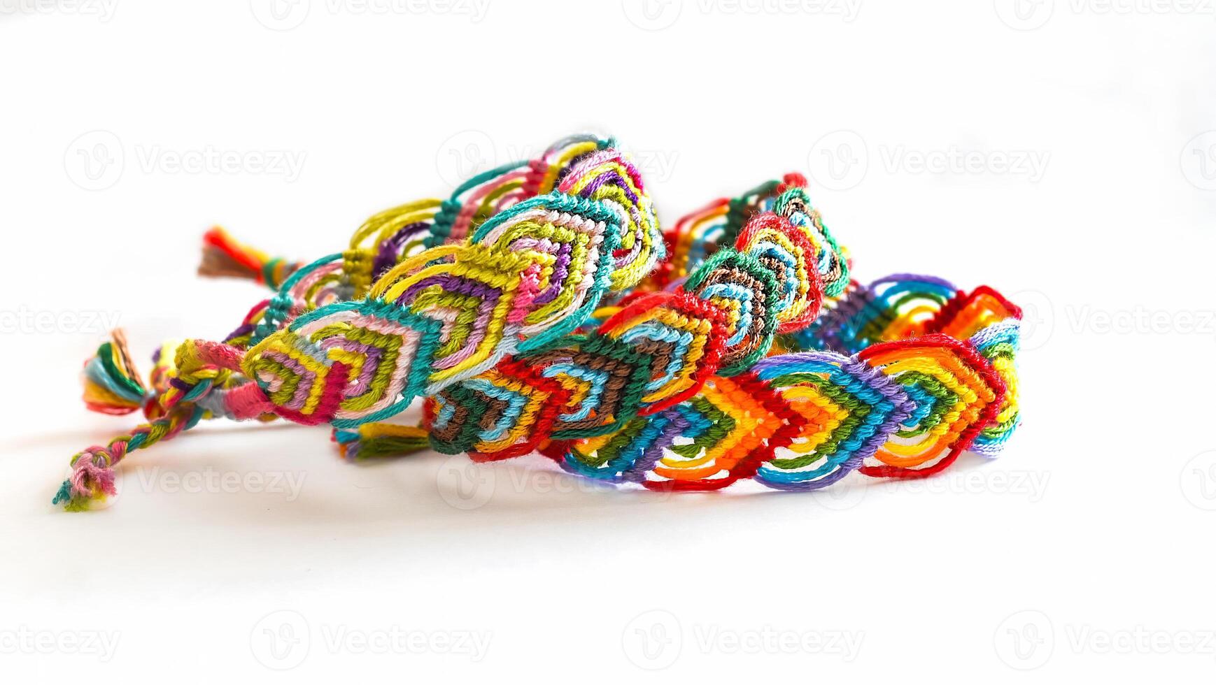 3 Multicolored woven friendship bracelets handmade of embroidery bright thread with knots isolated on white background photo