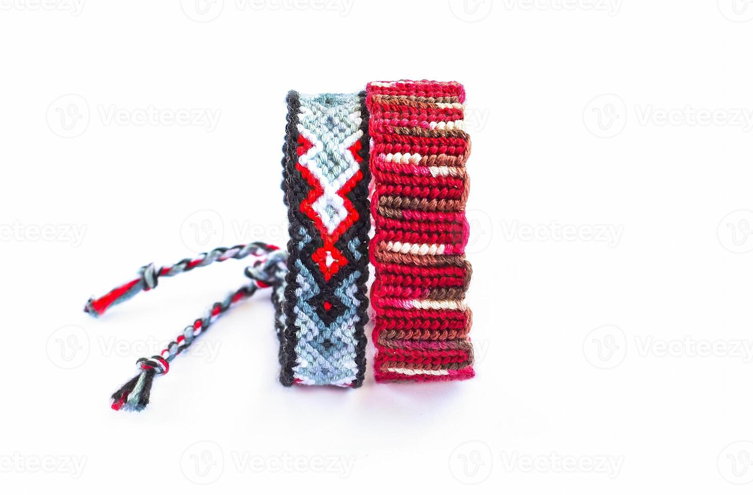 2 Multicolored woven DIY friendship bracelets handmade of embroidery bright thread with knots isolated photo