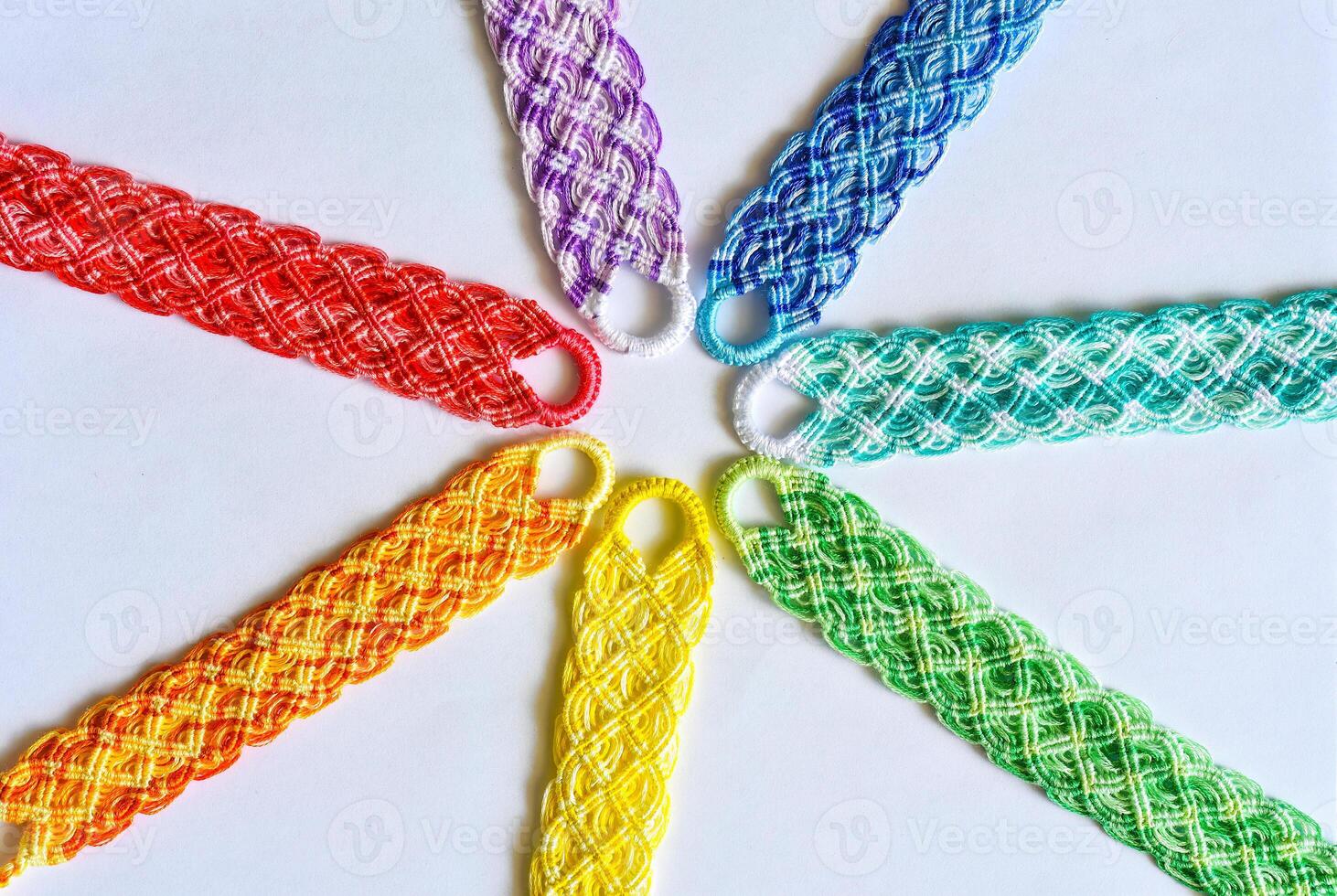 Multicolored woven DIY friendship bracelets handmade of thread with knots isolated on white background photo
