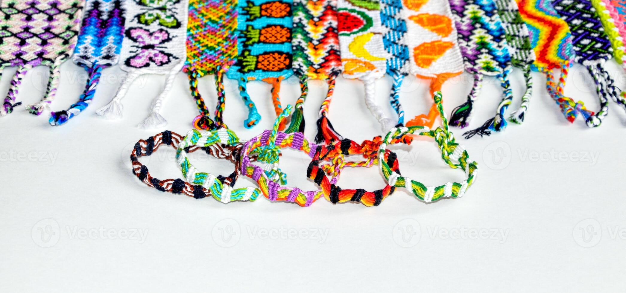 Multicolored DIY friendship bracelet handmade of embroidery bright thread with knots isolated on white background photo