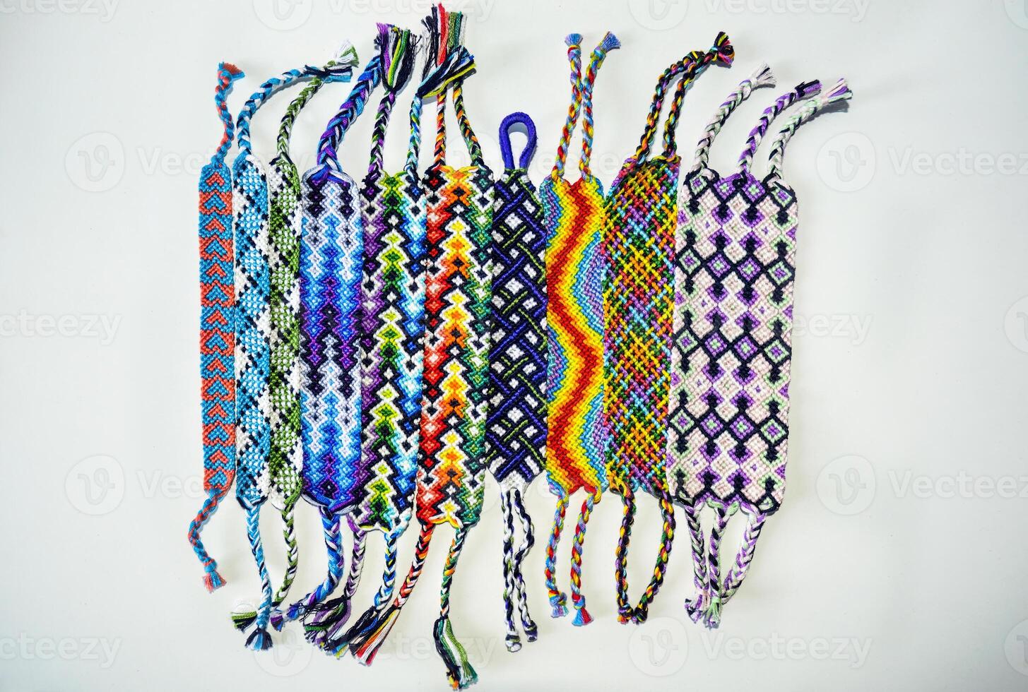 Multicolored woven DIY friendship bracelets made of embroidery bright thread with knots isolated on white background photo