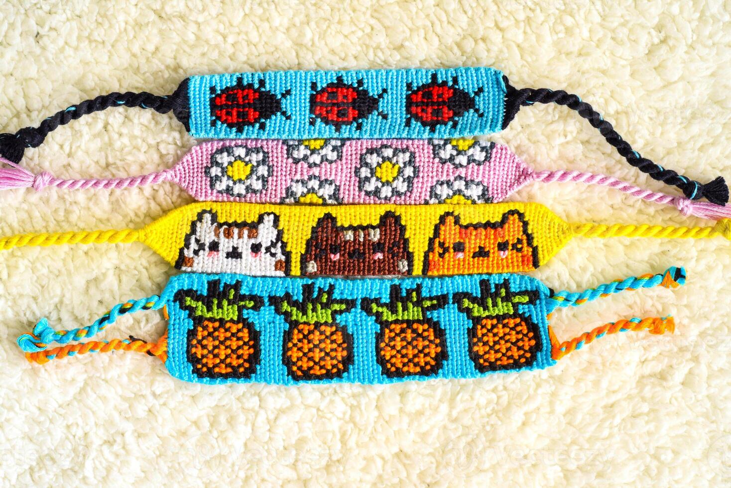 Woven DIY friendship bracelets handmade of an embroidery floss with knots, alpha patterns photo