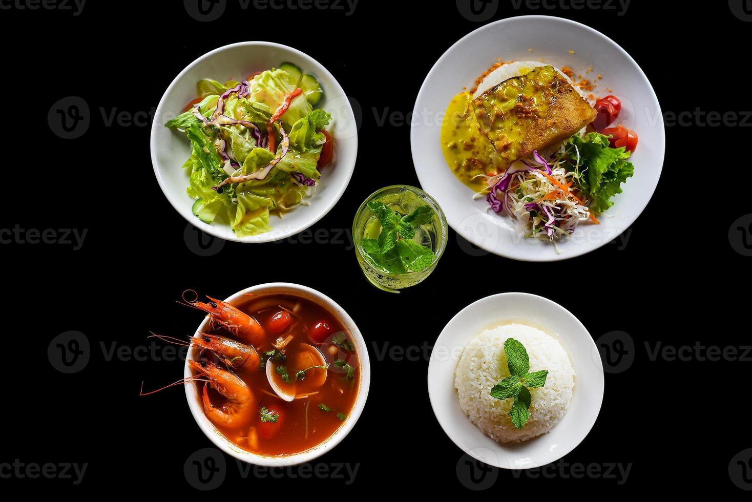 Lunch set made of tom yum soup, salad, grilled basa fish, rice, lemonade on black background photo
